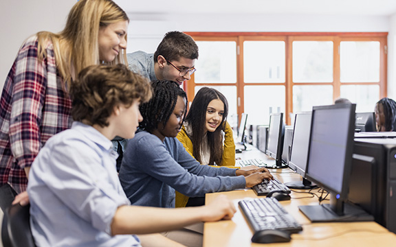 Schüler sitzen im Unterricht an Laptops
