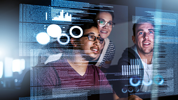A woman and 2 men look at a transparent video screen with data