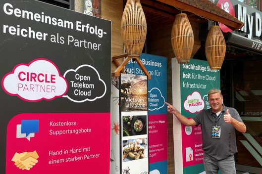 Mitarbeiter der T Cloud Public vor Werbeaufstellern auf der Digital X